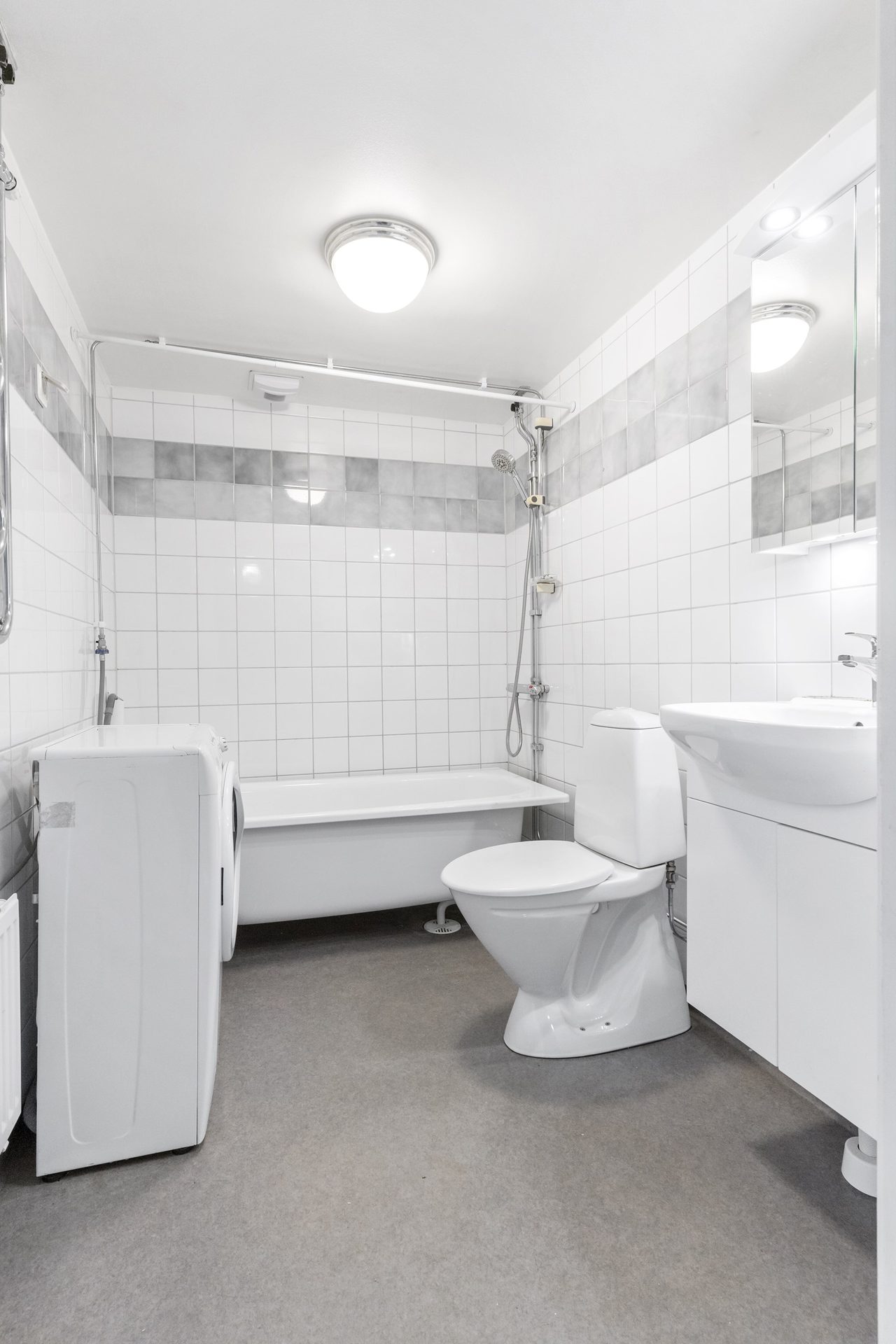 Stamrenoverat badrum med tvättmaskin.