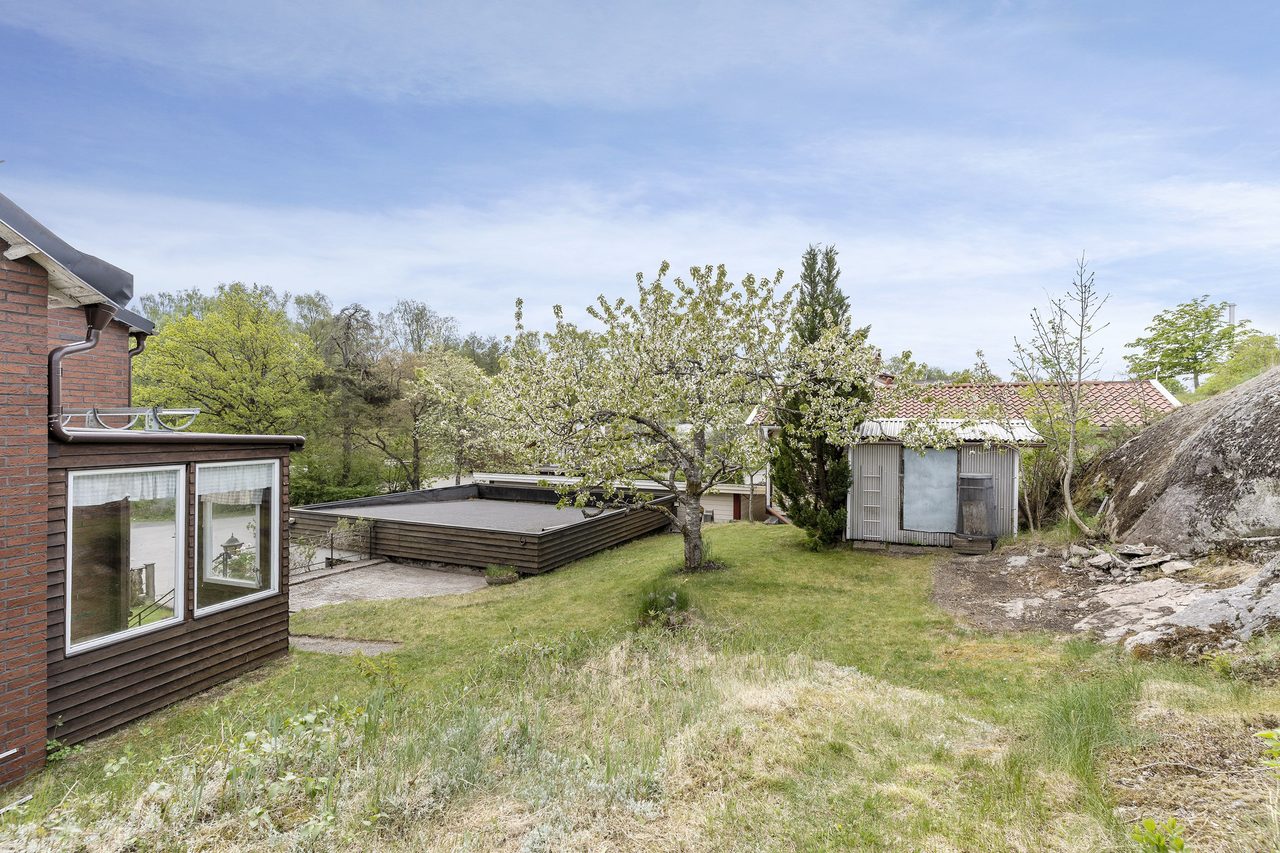 Högt belägen uteplats med sjöstensplattor.