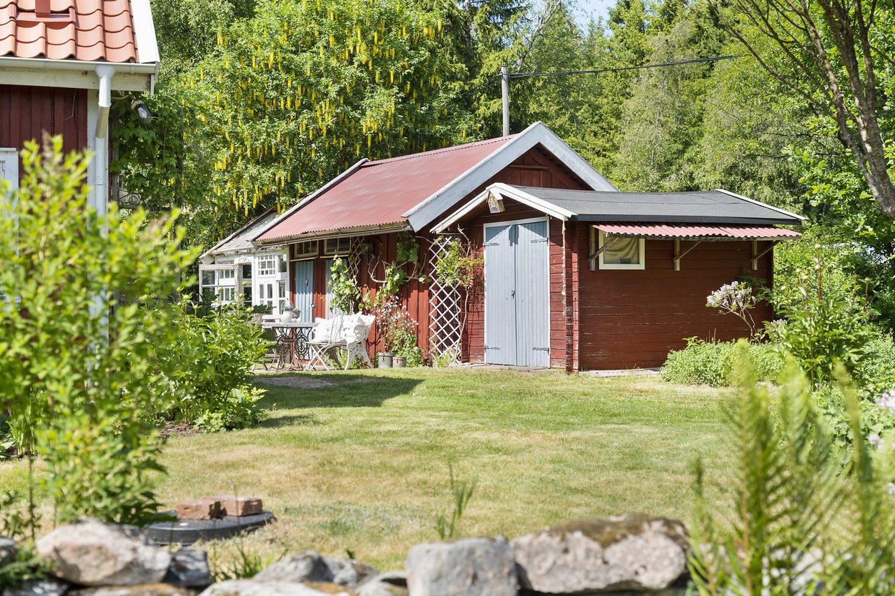 Ute finner ni välskött trädgård och ut uthus.