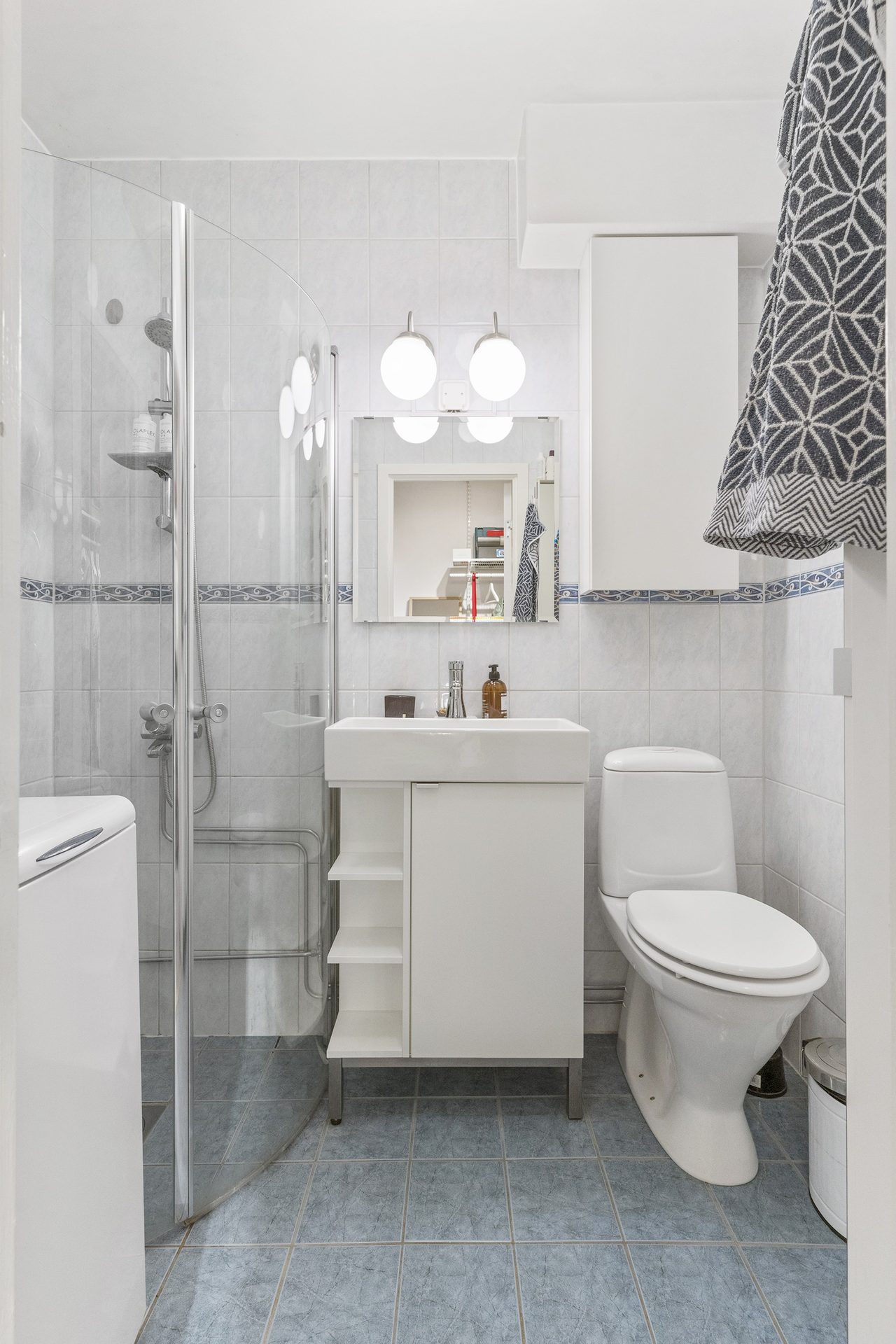 Stamrenoverat badrum med tvättmaskin.