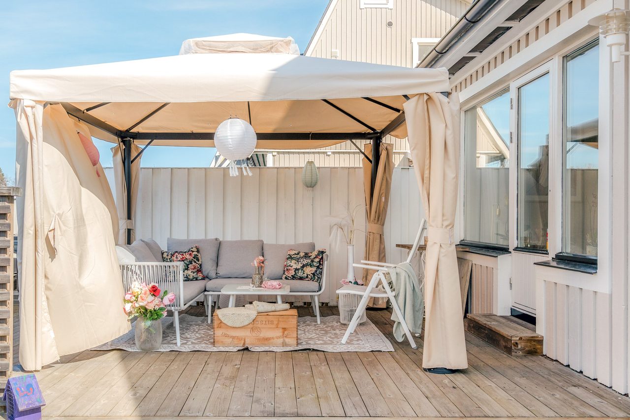 Stor altan på husets entrésida med kvällssol