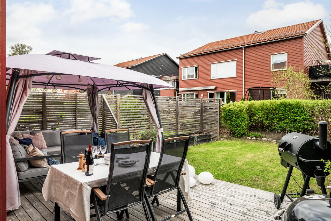 Underbar uteplats med stor altan och tillhörande trädgård