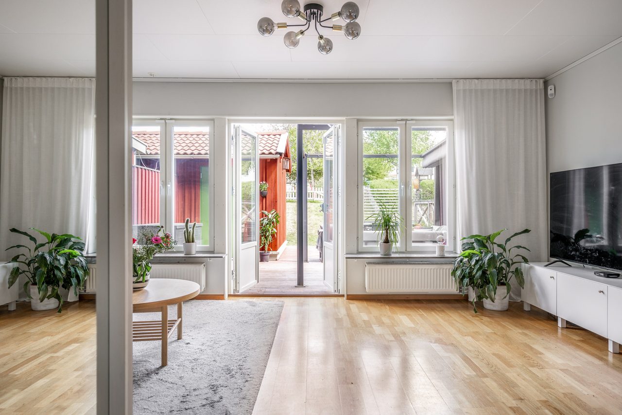 Ljust och rymligt vardagsrum med utgång till altan på baksidan
