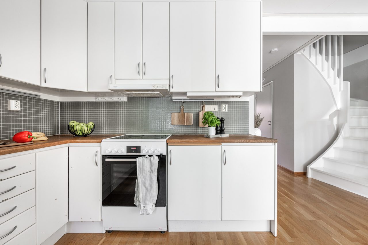Genomgående parkettgolv och vitt kök