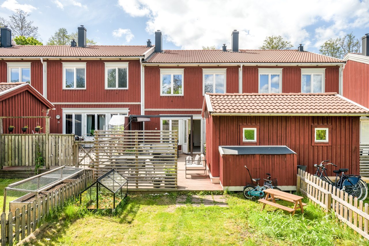 Uteplats med stor utbyggd altan och lättskött trädgård